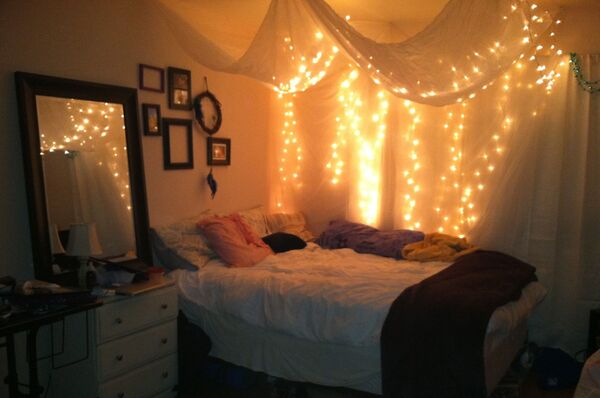 Quarto com candeeiro aceso, luz suave e cama preparada para o descanso